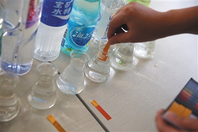 9月7日，北京智云达科技有限公司，工作人员用试纸检测瓶装水的酸碱度。